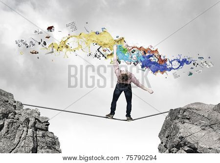 Young guy in casual evading from colorful paint splashes