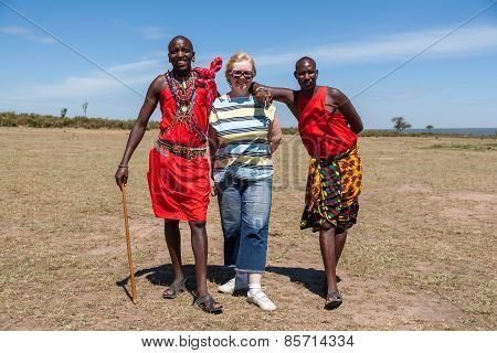 MASAI MARA,KENYA, AFRICA- FEB 12 Masai men in traditional clothes and European tourists, review of d