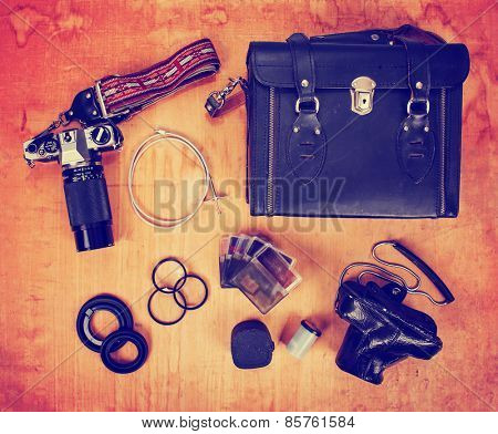 overhead image of old dirty scratched up gear needed for old school film photography enthusiasts including two cameras and filters toned with a retro vintage instagram filter effect app or action 
