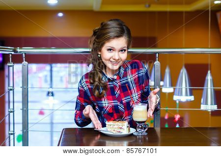 Young Beautiful Girl Shows To Cup Of Mokachino And Cake