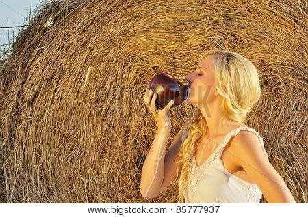 Happy woman drinking milk from cruse or crock