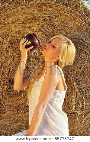 Happy woman drinking milk from cruse or crock
