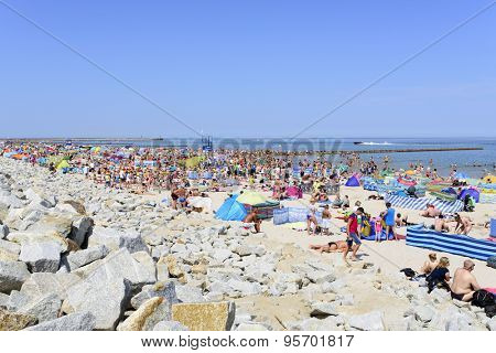 USTKA - JULY 04: Tourists enjoy the sunny weather and relaxing on the Baltic sea beach on 04 July 2015 in Ustka, Poland.