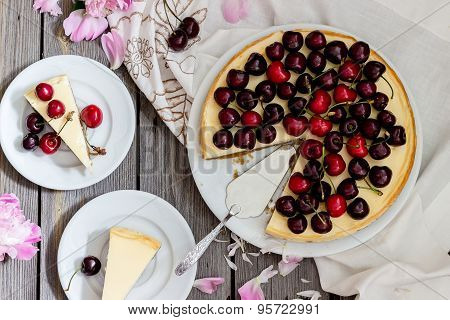 Cheesecake With Cherry, Two Slices On Saucers And Metal Tray  On A Wooden Table. .