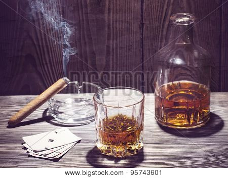 Cognac and cigar burning on a wooden table