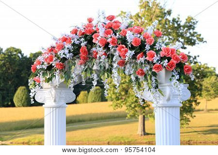 Wedding Arch With Pink Flowers And White Pillars