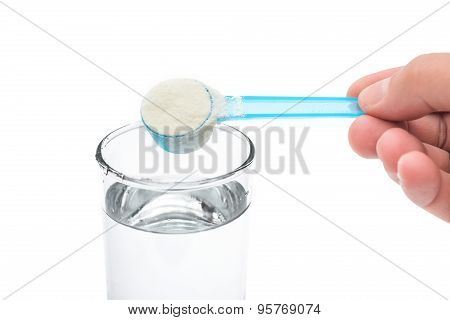 Putting Powdered Milk Into A Glass Cup With Clipping Path Close Up