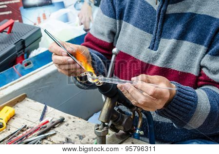 Craftsmen creates of colored glass miniature figurine of an unicorn.