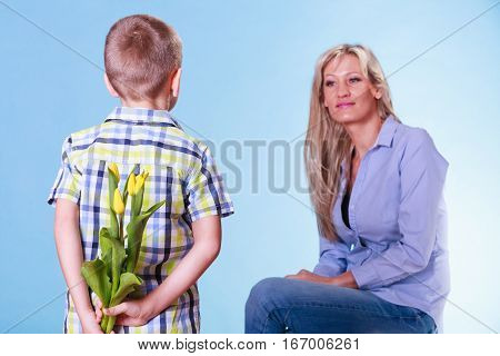 Special occasions holiday and mother day. Young boy prepare surprise gift flowers hold tulips behind back mother sit smiling.