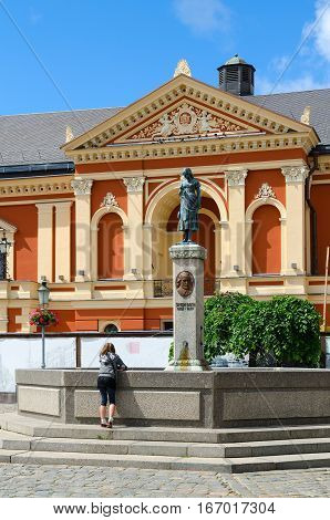 KLAIPEDA LITHUANIA - JULY 11 2015: Unknown girl is near monument to Simon Dach (sculpture Annhen of Tarau) at Drama Theatre on Theatre Square Klaipeda Lithuania