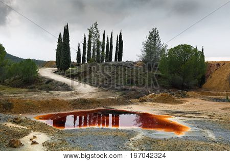 Lake with red polluted toxic water of an Abandoned copper mine at Mitsero area in Cyprus