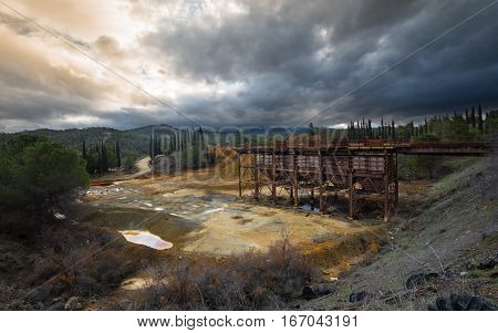 Rusty platform of an old Abandoned copper mine with dramatic stormy cloudy sky at Mitsero area in Cyprus