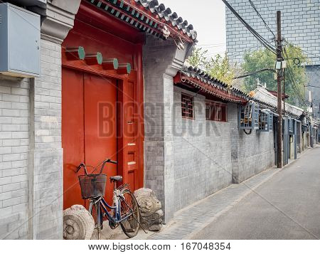 Beijing, China - Oct 30, 2016: Traditional Chinese home entrance in typical red color and design. Such architecture style is common in Old Beijing streets or alleys called Hutongs.