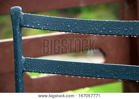 patio chair backrest with rain drops on overcast rainy day