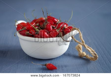 fresh undried goji berries in front of a blue wooden background