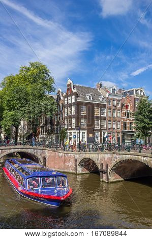 AMSTERDAM, NETHERLANDS - SEPTEMBER 18, 2016: Tourist cruiseboat in the canals of historical Amsterdam, Holland