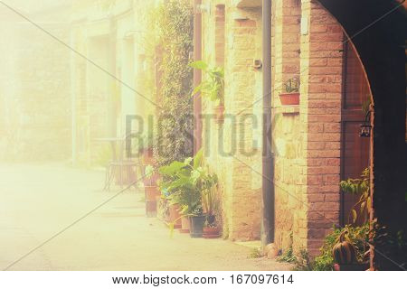 Empty street of small Tuscany town San Quirico d'Orcia in the morning fog, romantic travel vintage hipster european italy background with copy space