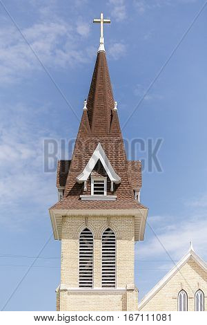 A church steeple with cross and angled roofs