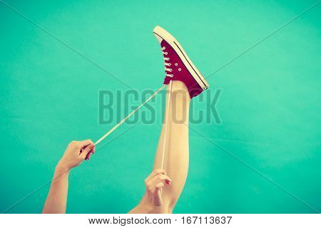 Person Tying Red Sneaker With Foot Up