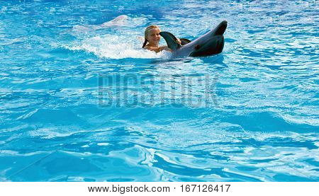 Happy child and dolphins in blue water. Dolphin Assisted Therapy