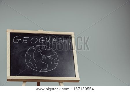 Geography Lesson On Blackboard Or Chalkboard. Written In White Chalk