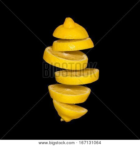 Flying lemon. Sliced lemon isolated on black background. Levity fruit floating in the air