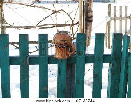 ceramic glechik upside-down weighs on the fence
