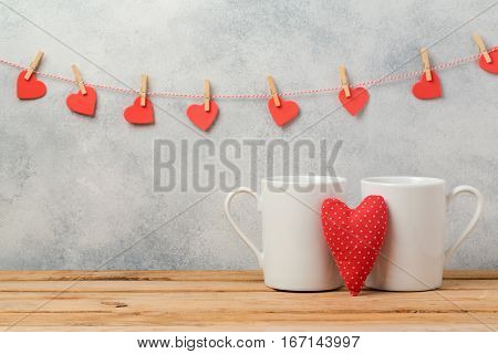 Valentines day concept with white coffee cups and heart shape over rustic background