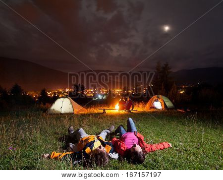 Twosome Admiring The Bright Stars And Lying On The Grass