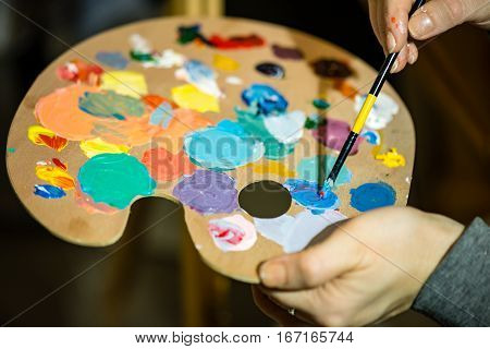 Artist Painting With Acrylic Colors And Mixing Tones