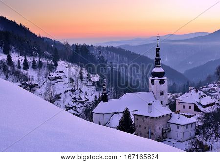 Sunset at winter in Slovakia. Old mining village. Historic church in Spania dolina.