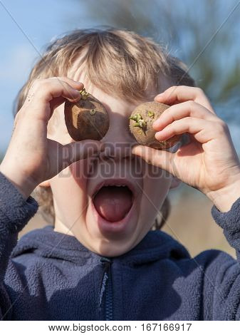 Portrait of boy playing with sprouted potatoes
