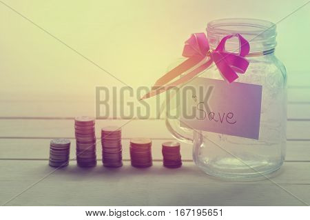 pile of money coins with save word on paper and bottle of piggy bank for saving and business concept