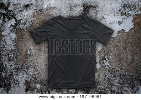 Grey t-shirt on concrete on wall background.