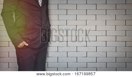 businessman standing on brick wall background with copy space