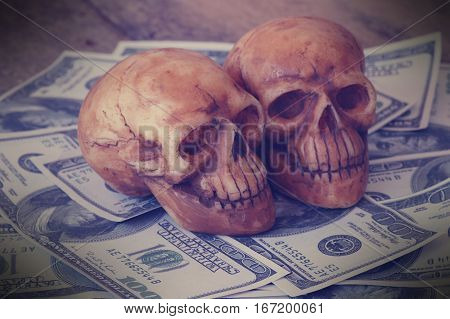skull on bank note and coin money concept in work for money and death because of money