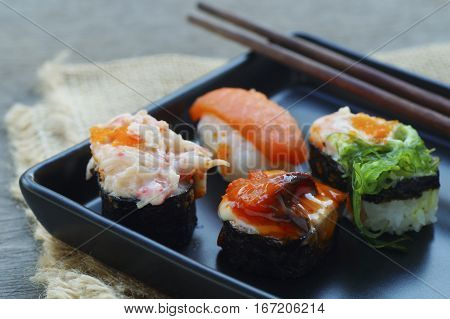 food shushi on black plate in restaurant