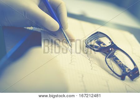 Doctor monitoring the patients cardiogram in office.