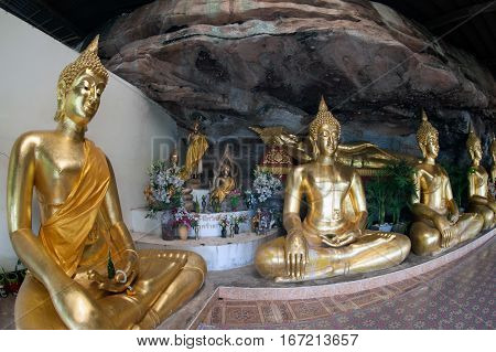 UBON RATCHATANI,THAILAND -JANUARY 17,2017 : Row of golden Buddha in the cave of Wat Tham Khuha Sawan temple is located on a high cliff above the river Mekong .Khong Chiam District , Ubon Ratchathani, Thailand.