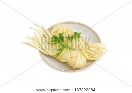 Two portions of the mozzarella cheese in the form of strings twisted in a shape of a plait and twig of parsley on the saucer on a light background