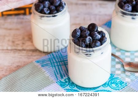Homemade yogurt with blueberries in a glass jar
