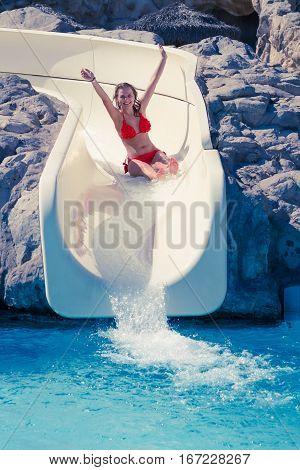 Blond Girl Riding Slide In Waterpark