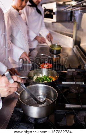 Group of chef preparing food in the kitchen of a restaurant