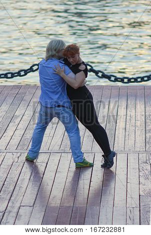 embankment of Gorki Park Moscow Russia - July 31 2016: man and girl dancing the hustle at the embankment of Moscow River