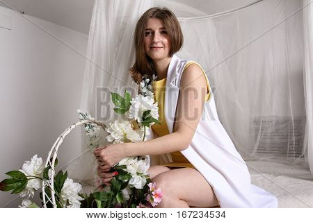 Beautiful girl sitting on a bed under a baldachin