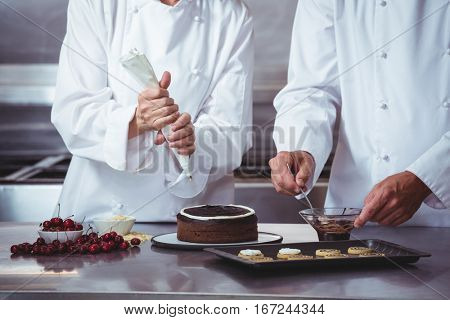 Chefs decorating a cake in a restaurant