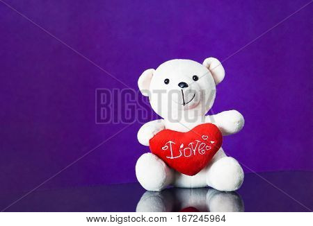 Teddy bear with heart sitting on the glass with  purple background. Get Taste Forever Valentine.