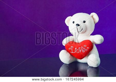 Teddy bear with heart sitting on the glass with  purple background. Get Taste Forever Valentine.