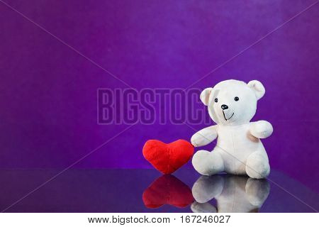 Teddy bear with heart sitting on the glass with  purple background. Get Taste Forever Valentine.