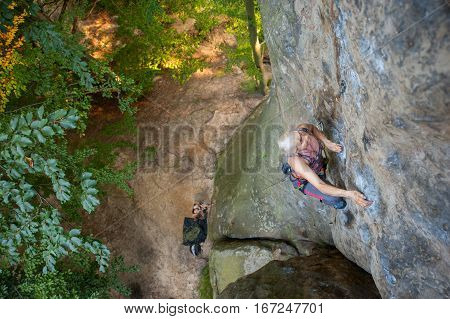 Woman Rock Climber Is Climbing On A Rocky Wall